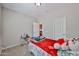 Cozy bedroom featuring neutral paint, carpet and a comfortable bed topped with red blanket at 30263 W Crittenden Ln, Buckeye, AZ 85396