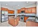 Kitchen featuring an island, granite countertops, stainless appliances, and wood cabinetry at 30263 W Crittenden Ln, Buckeye, AZ 85396