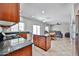 Kitchen with wood cabinets, stainless appliances, granite countertops, and open view into the living area at 30263 W Crittenden Ln, Buckeye, AZ 85396