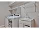 Functional laundry room featuring a washing machine, dryer, shelving and a utility sink at 30263 W Crittenden Ln, Buckeye, AZ 85396