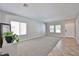 Inviting living room with neutral carpeting, two windows, and a white door at 30263 W Crittenden Ln, Buckeye, AZ 85396