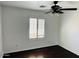Bright bedroom featuring dark wood floors, ceiling fan, and a window with plantation shutters at 3502 W Belle Ave, San Tan Valley, AZ 85144