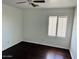 Bright bedroom featuring dark wood floors, ceiling fan, and a window with plantation shutters at 3502 W Belle Ave, San Tan Valley, AZ 85144