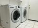 Bright laundry room featuring a white washer and dryer set and tile flooring at 3633 E Potter Dr, Phoenix, AZ 85050