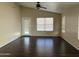 Living room featuring dark wood floors, a ceiling fan, and a glass door to the backyard at 3633 E Potter Dr, Phoenix, AZ 85050