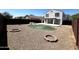 Spacious backyard featuring gravel, a putting green, patio, and multiple firepit areas, great for outdoor enjoyment at 37061 W Bello Ln, Maricopa, AZ 85138