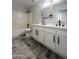 Modern bathroom featuring double sinks, herringbone tile floors, and sleek black fixtures at 37061 W Bello Ln, Maricopa, AZ 85138