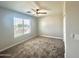 Bedroom features a ceiling fan, neutral paint, plush carpeting, and a window with blinds at 37061 W Bello Ln, Maricopa, AZ 85138