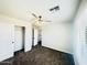 This bedroom offers a closet, ceiling fan, neutral paint, plush carpeting, and a window with blinds at 37061 W Bello Ln, Maricopa, AZ 85138