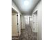 Long hallway with carpet and white doors leading to various rooms of the house at 37061 W Bello Ln, Maricopa, AZ 85138