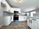 Charming kitchen featuring white cabinets, stainless steel appliances, and tile backsplash at 37061 W Bello Ln, Maricopa, AZ 85138
