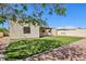 Spacious backyard with artificial grass, rock landscaping, and a covered patio at 4231 W Villa Maria Dr, Glendale, AZ 85308