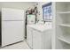 Bright laundry room with white washer, dryer, and refrigerator plus water heater at 4231 W Villa Maria Dr, Glendale, AZ 85308