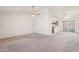 Open-concept living room features light carpet, a ceiling fan, and views into the kitchen at 4231 W Villa Maria Dr, Glendale, AZ 85308