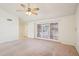 A spacious living room features light carpet, a ceiling fan, and large windows for natural light at 4231 W Villa Maria Dr, Glendale, AZ 85308