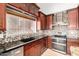 Stylish kitchen featuring a black sink and backsplash, dark wood cabinets, and stainless steel appliances at 4304 N Ranier --, Mesa, AZ 85215