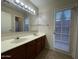 Well-lit bathroom with a double sink vanity, a large mirror, and a door to the exterior at 4332 E Frye Rd, Phoenix, AZ 85048