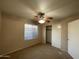 Cozy bedroom featuring a ceiling fan, neutral carpet, and closet with sliding doors at 4332 E Frye Rd, Phoenix, AZ 85048