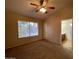 Comfortable bedroom features plush carpeting, a ceiling fan, and a large window for natural light at 4332 E Frye Rd, Phoenix, AZ 85048