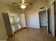 Cozy bedroom with neutral walls, tile flooring, a ceiling fan, and two large closets at 4332 E Frye Rd, Phoenix, AZ 85048