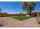 The backyard is spacious, low maintenance with rocks, gravel and a patch of artificial turf at 43949 W Sagebrush Trl, Maricopa, AZ 85138