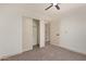 Clean bedroom with neutral carpet, a ceiling fan, and a closet with sliding doors at 43949 W Sagebrush Trl, Maricopa, AZ 85138