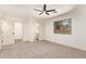 Cozy bedroom featuring a ceiling fan, plush carpet, and ensuite bath at 43949 W Sagebrush Trl, Maricopa, AZ 85138