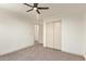 Neutral bedroom with a ceiling fan, gray carpet, and a closet with sliding doors at 43949 W Sagebrush Trl, Maricopa, AZ 85138