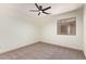 This bedroom features carpeted floors, a ceiling fan, and a window at 43949 W Sagebrush Trl, Maricopa, AZ 85138