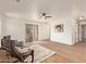 Open living room featuring hardwood floors, a ceiling fan, modern furniture, and natural light at 43949 W Sagebrush Trl, Maricopa, AZ 85138