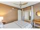 Well-lit bedroom featuring a ceiling fan, a sliding barn door, and access to the closet and bathroom at 4525 N 66Th St # 10, Scottsdale, AZ 85251