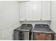 Laundry room featuring two Samsung washing machines and white overhead cabinets for convenient storage at 4525 N 66Th St # 10, Scottsdale, AZ 85251