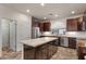 Well-lit kitchen featuring a marble island, dark wood cabinets, and stainless steel appliances at 4649 E Sourwood Dr, Gilbert, AZ 85298