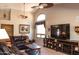 Bright living room featuring a high ceiling, ceiling fans, a large television, and comfortable seating arrangement at 5023 S Dusty Coyote Trl, Gold Canyon, AZ 85118