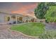 Lush backyard with a manicured lawn, covered patio, and decorative rock border at 5283 W Dublin Ct, Chandler, AZ 85226