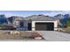 Charming single-story home features neutral stucco, grey roof, two-car garage and desert landscaping at 5457 E Mearn Rd, San Tan Valley, AZ 85140
