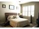 Cozy bedroom with a rustic wood headboard, plush bedding, and plantation shutters at 6885 E Cochise Rd # 127, Paradise Valley, AZ 85253