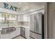 Bright updated kitchen with white cabinets, quartz countertops, and stainless steel refrigerator at 6885 E Cochise Rd # 127, Paradise Valley, AZ 85253
