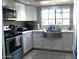 Bright kitchen with white cabinets, stainless steel appliances, and a stainless farmhouse sink at 6885 E Cochise Rd # 127, Paradise Valley, AZ 85253