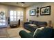 Bright living room with a large sofa, decorative art, a ceiling fan and a view to the patio at 6885 E Cochise Rd # 127, Paradise Valley, AZ 85253