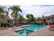 Inviting community pool with lounge chairs, tables, umbrellas and lush landscaping at 6885 E Cochise Rd # 127, Paradise Valley, AZ 85253