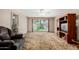 Comfortable living room with a large window, plush carpeting, and a vintage entertainment center at 6902 E Cypress St, Scottsdale, AZ 85257