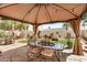 Outdoor dining area under gazebo with decorative plants and grass at 7921 E Bonita Dr, Scottsdale, AZ 85250