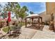 Outdoor patio area with seating and a gazebo, enhanced by decorative plants, a red umbrella, and desert landscaping at 7921 E Bonita Dr, Scottsdale, AZ 85250
