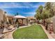 Well-maintained backyard featuring a green lawn, an outdoor dining area with a gazebo, and desert landscaping at 7921 E Bonita Dr, Scottsdale, AZ 85250