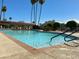Large community pool featuring lounge chairs, palm trees, and manicured landscaping at 7921 E Bonita Dr, Scottsdale, AZ 85250