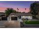 Charming home featuring a well-manicured yard, a modern garage door, and desert landscaping at 8544 E Heatherbrae Dr, Scottsdale, AZ 85251