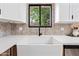 Farmhouse sink paired with modern black faucet under a bright window, adding charm and functionality at 8544 E Heatherbrae Dr, Scottsdale, AZ 85251