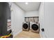 Bright laundry room features stainless steel appliances and shelving for organization at 8544 E Heatherbrae Dr, Scottsdale, AZ 85251