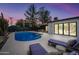 Backyard oasis with a refreshing pool, comfortable lounge chairs, and lush landscaping at dusk at 8544 E Heatherbrae Dr, Scottsdale, AZ 85251